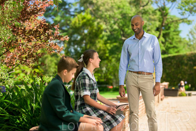 January 2024 / Teacher-Standing-with-2-Studenst-Sitting-Outdoors_240122_Z9E8465