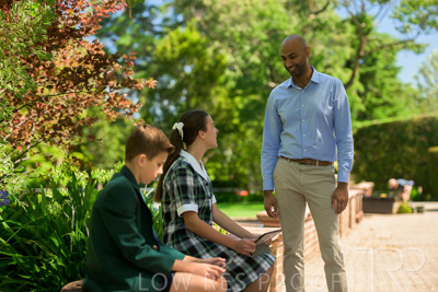 January 2024 / Teacher-Standing-with-2-Studenst-Sitting-Outdoors_240122_Z9E8479