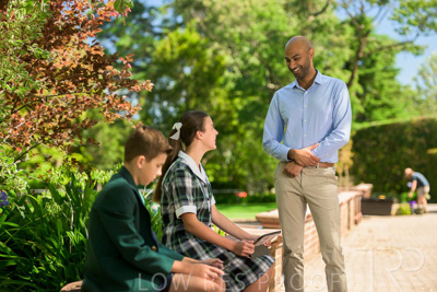 January 2024 / Teacher-Standing-with-2-Studenst-Sitting-Outdoors_240122_Z9E8490