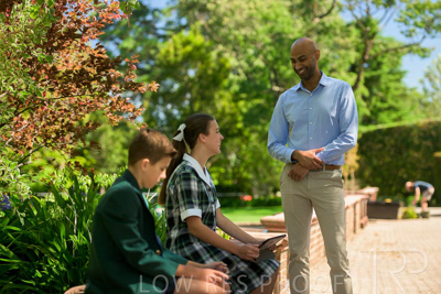 January 2024 / Teacher-Standing-with-2-Studenst-Sitting-Outdoors_240122_Z9E8497