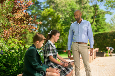 January 2024 / Teacher-Standing-with-2-Studenst-Sitting-Outdoors_240122_Z9E8502