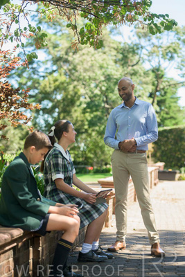 January 2024 / Teacher-Standing-with-2-Studenst-Sitting-Outdoors_240122_Z9E8508