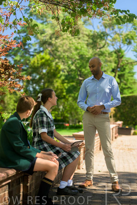 January 2024 / Teacher-Standing-with-2-Studenst-Sitting-Outdoors_240122_Z9E8510