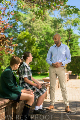 January 2024 / Teacher-Standing-with-2-Studenst-Sitting-Outdoors_240122_Z9E8511