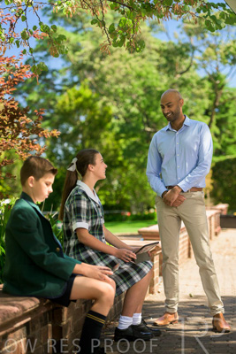 January 2024 / Teacher-Standing-with-2-Studenst-Sitting-Outdoors_240122_Z9E8519