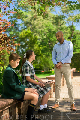 January 2024 / Teacher-Standing-with-2-Studenst-Sitting-Outdoors_240122_Z9E8525