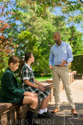 January 2024 / Teacher-Standing-with-2-Studenst-Sitting-Outdoors_240122_Z9E8529
