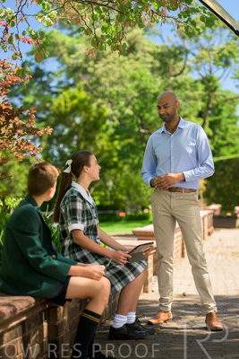 January 2024 / Teacher-Standing-with-2-Studenst-Sitting-Outdoors_240122_Z9E8541