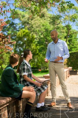 January 2024 / Teacher-Standing-with-2-Studenst-Sitting-Outdoors_240122_Z9E8545