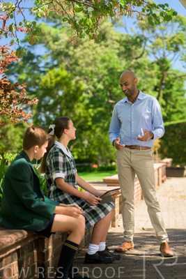 January 2024 / Teacher-Standing-with-2-Studenst-Sitting-Outdoors_240122_Z9E8546