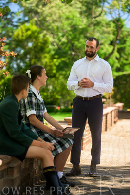 January 2024 / Teacher-Standing-with-2-Studenst-Sitting-Outdoors_240122_Z9E8623