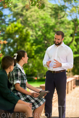 January 2024 / Teacher-Standing-with-2-Studenst-Sitting-Outdoors_240122_Z9E8636