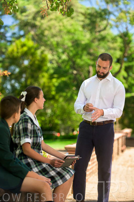 January 2024 / Teacher-Standing-with-2-Studenst-Sitting-Outdoors_240122_Z9E8638