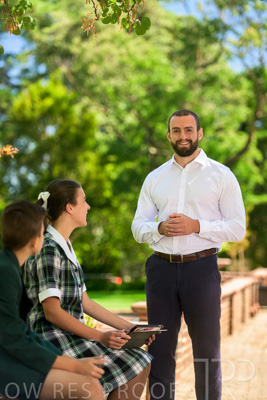 January 2024 / Teacher-Standing-with-2-Studenst-Sitting-Outdoors_240122_Z9E8647