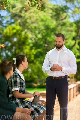 January 2024 / Teacher-Standing-with-2-Studenst-Sitting-Outdoors_240122_Z9E8659